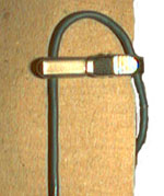 Cable engaged by tie bar behind clothing to reduce vibration.